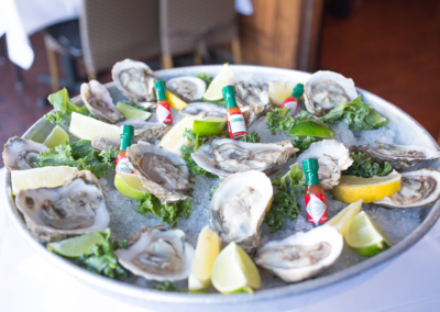 A plate of Oysters with ice, Lemon slices and Tabasco hot sauce