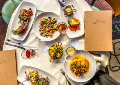 alt="a table topped with plates of food and drinks in Osteria Panevino Restaurant"