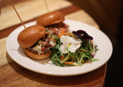 a plate of salad an a hamburguer on a table