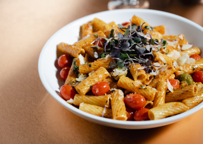 A bowl of pasta with tomato and cheese on it