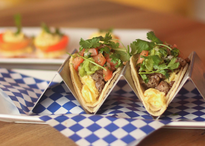 A plate with tacos topped with pico de gallo, meat and cilantro