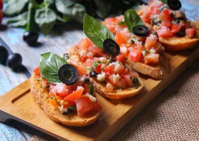 alt="several pieces of bread with olives and tomatoes on them"
